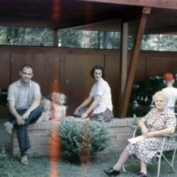 Family sitting under a carport