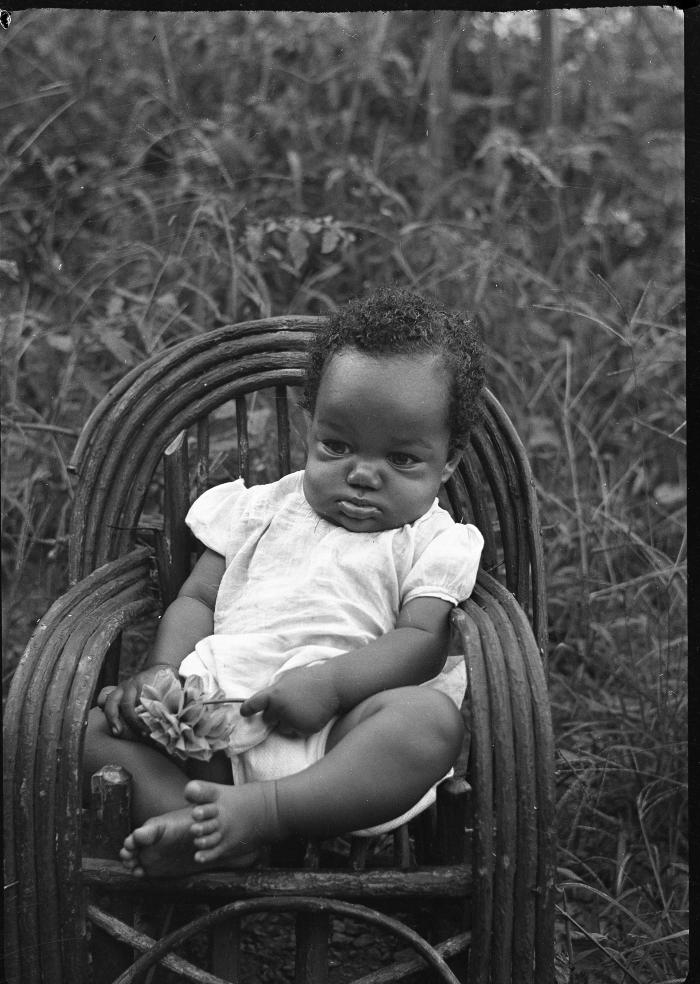 A baby sitting in a chair outdoors