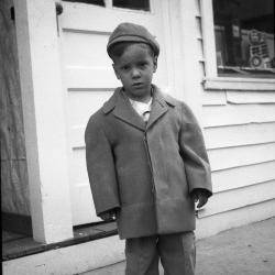 Boy posing in front of white house