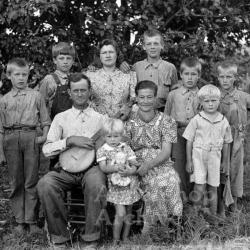 Exterior portrait of large family, man holding banjo