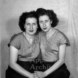 Studio portrait of 2 women in matching outfits