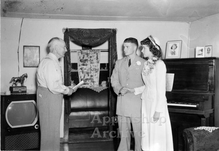 Interior portrait of couple being married by preacher