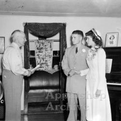 Interior portrait of couple being married by preacher