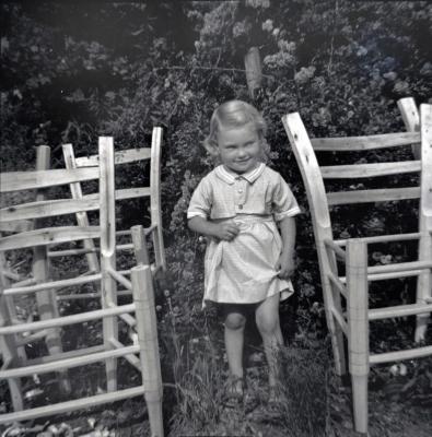 Young girl surrounded by chair frames