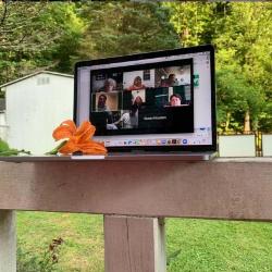 Monitor on porch railing displays virtual meeting