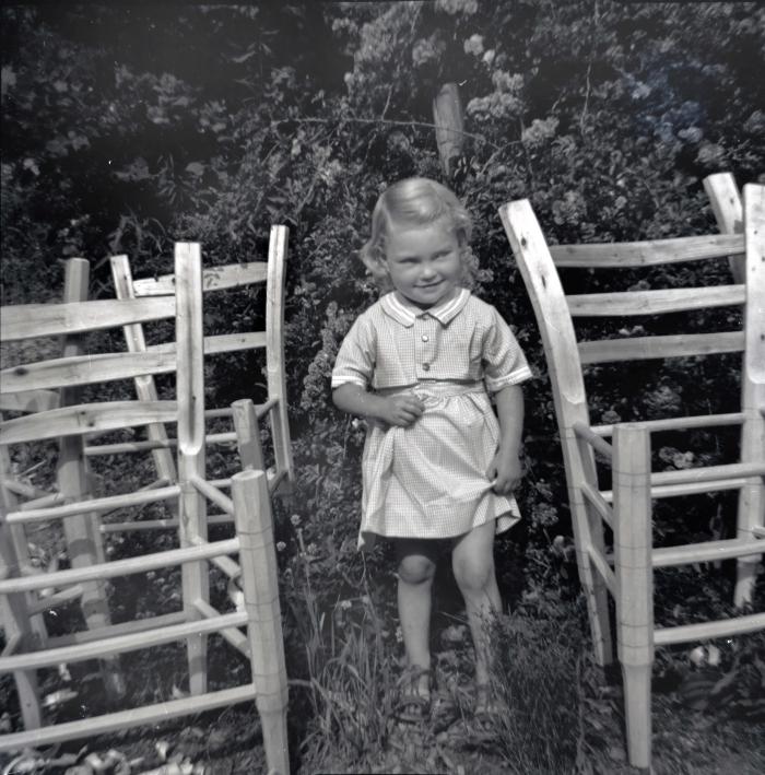 Young girl surrounded by chair frames
