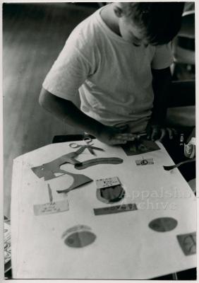 Production still of child making a collage - The Struggle of Coon Branch Mountain