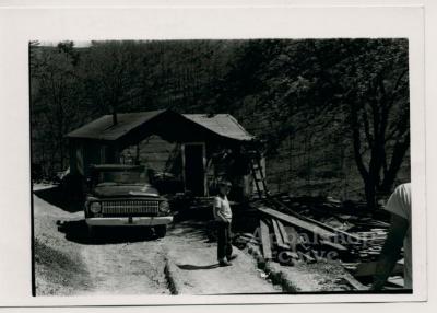 Production still of standing in front of rural house - The Struggle of Coon Branch Mountain