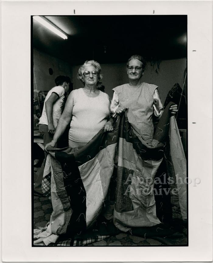 Production still of two women holding quilt - Millstone Sewing Center 